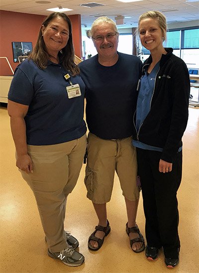 two woman and one man smiling