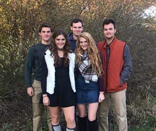 two sisters and three brothers smiling in wooded area